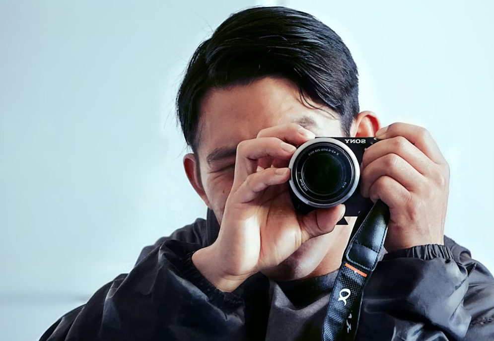 Man holding a camera eye level to take a picture