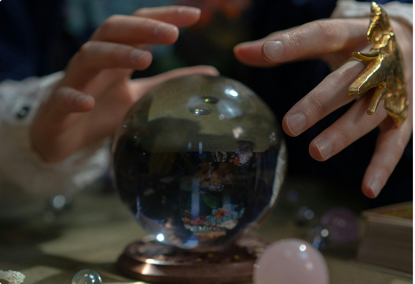 hands hovering over a crystal ball