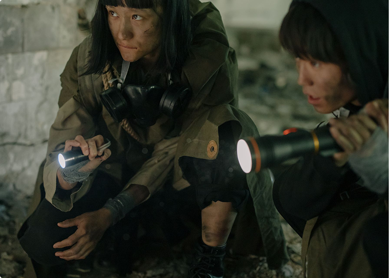 A woman and child searching with flashlights